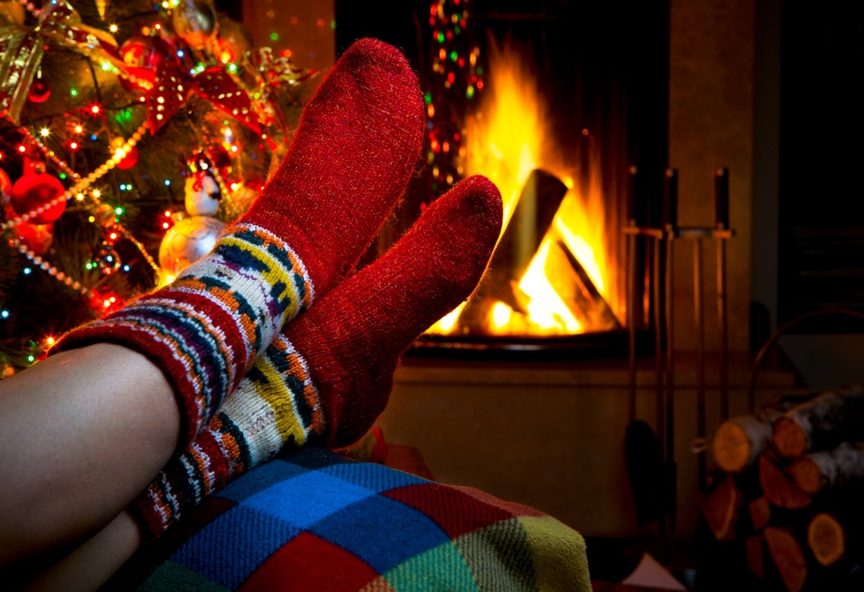 Have a relaxing Christmas charity eCard. Feet in new pair of sock by the fire
