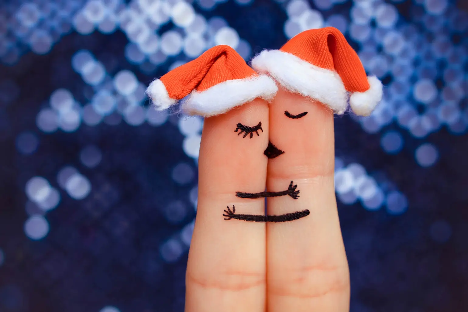 Kissing fingers wearing santa hats